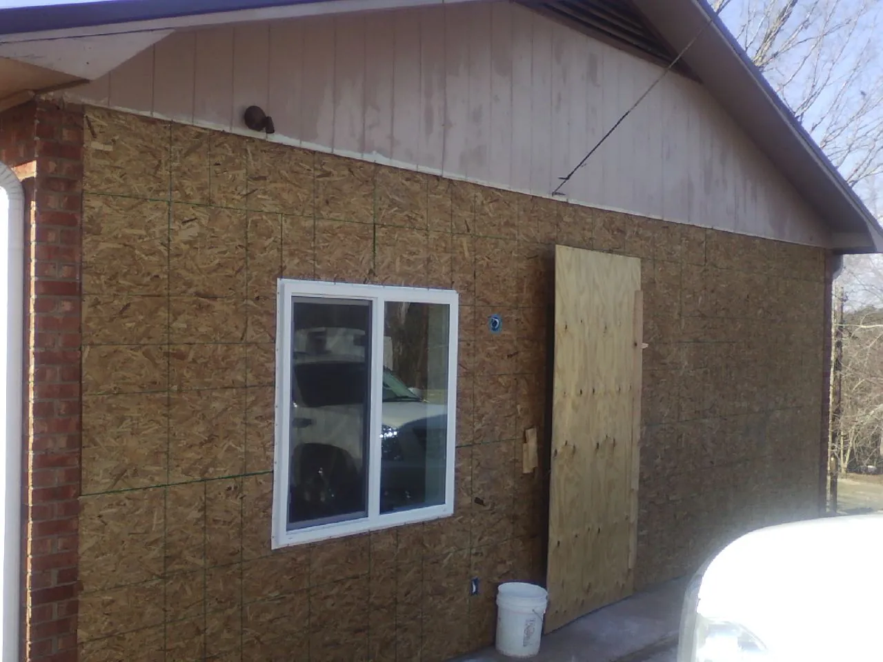 OSB sheathing on a garage addition wall before siding in Otsego
