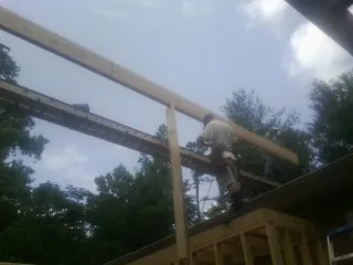 Carpenter setting a ridge beam over a new addition frame — Ice Dam Removal by Roofing Brothers in Otsego