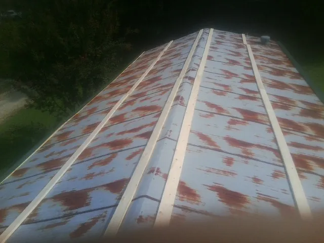 Rusted metal roof panels with new wood purlins before replacement — Storm Damage Roof Repair in Otsego by Roofing Brothers