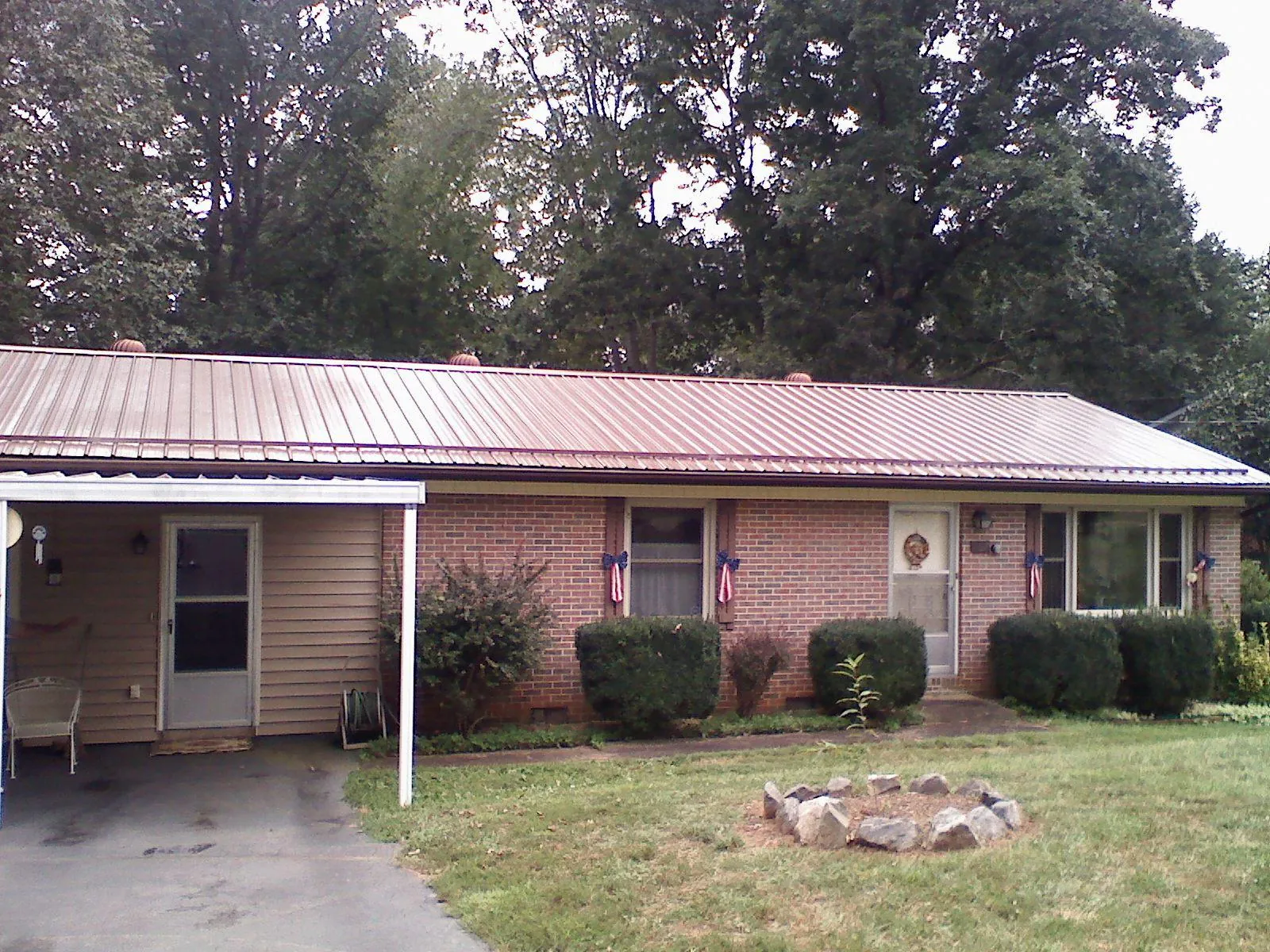 Bronze metal roof and carport on a brick ranch home — Roof Repair work by our crew in Otsego