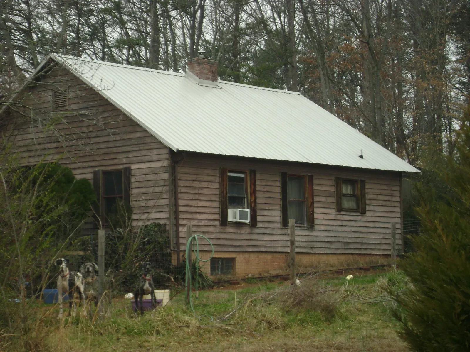 White metal roof on an old wood sided farmhouse, from a Metal Roof Installation job in Otsego